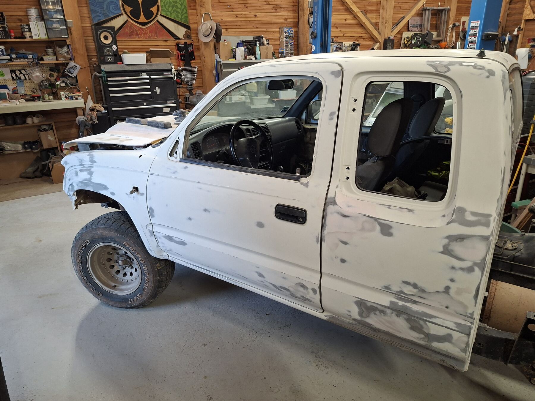 Cabine de pick-up sur chevalets, flanc entièrement repris au mastic et poncé