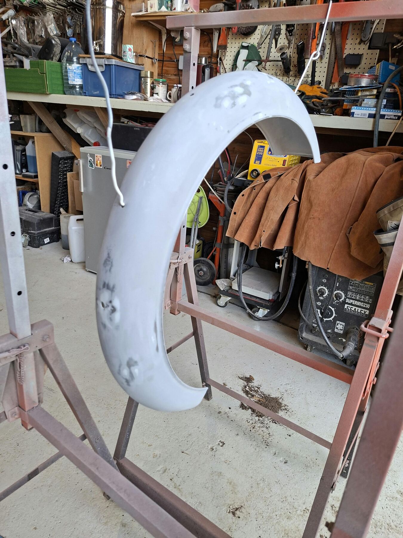 Aile de collection en apprêt devant le poste à souder MIG et le mur d’outils